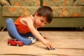 Little boy playing toy cars on the floor