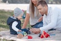 Little boy playing toy cars and having fun with his father and mother outdoors Royalty Free Stock Photo