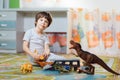 Little boy playing toy cars on play mat. Young kid with colorful educational vehicle and transport toys on carpet. City street map Royalty Free Stock Photo