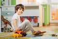 Little boy playing toy cars on play mat. Young kid with colorful educational vehicle and transport toys on carpet. City street map Royalty Free Stock Photo