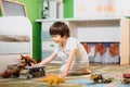 Little boy playing toy cars on play mat. Young kid with colorful educational vehicle and transport toys on carpet. City street map Royalty Free Stock Photo