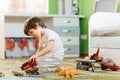 Little boy playing toy cars on play mat. Young kid with colorful educational vehicle and transport toys on carpet. City street map Royalty Free Stock Photo