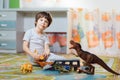 Little boy playing toy cars on play mat. Young kid with colorful educational vehicle and transport toys on carpet. City Royalty Free Stock Photo