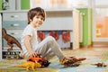 Little boy playing toy cars on play mat. Young kid with colorful educational vehicle and transport toys on carpet. City Royalty Free Stock Photo