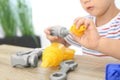 Little boy playing with toy construction tools at wooden table, closeup Royalty Free Stock Photo