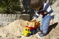 Little boy playing with toy digger and dumper truck. Royalty Free Stock Photo