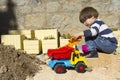 Little boy playing with toy digger and dumper truck. Royalty Free Stock Photo