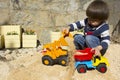 Little boy playing with toy digger and dumper truck. Royalty Free Stock Photo