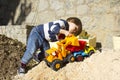 Little boy playing with toy digger and dumper truck. Royalty Free Stock Photo