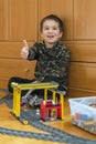 Little boy playing with a toy railway. Little boy playing with railway lying on the floor. Joyful emotions. vertical photo Royalty Free Stock Photo