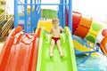 Little boy playing on water slide in outdoor pool on a hot summer day Royalty Free Stock Photo