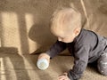 A little boy plays with a baby bottle with a nipple filled with milk formula for feeding Royalty Free Stock Photo