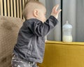 A little boy plays with a baby bottle with a nipple filled with milk formula for feeding Royalty Free Stock Photo