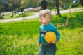 Little boy plays ball. Child on background of grass and trees Royalty Free Stock Photo