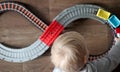 A little boy plays a children`s railway. Mom is watching her son from above. The child is fascinated by the train