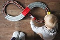 A little boy plays a children`s railway. Mom is watching her son from above. The child is fascinated by the train