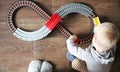 A little boy plays a children`s railway. Mom is watching her son from above. The child is fascinated by the train