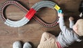 A little boy plays a children`s railway. Mom is watching her son from above. The child is fascinated by the train