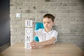 Little boy plays with cubes and puts it together in word Royalty Free Stock Photo