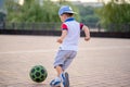 Little boy plays football on the football field gives a pass hits the ball runs across the field and scores a goal. Royalty Free Stock Photo