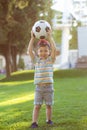 Little boy plays football on the football field gives a pass hits the ball runs across the field and scores a goal Royalty Free Stock Photo