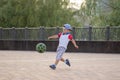 Little boy plays football on the football field gives a pass hits the ball runs across the field and scores a goal. Royalty Free Stock Photo