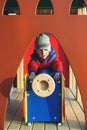 Little boy plays at modern city playground in cold day. Happy childhood. Modern kids colorful playground. Kids fashion. Autumn or Royalty Free Stock Photo