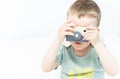 The little boy plays photographer with toy wooden camera Royalty Free Stock Photo