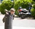 Little boy plays with public fountain water in park