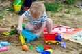 Little boy plays in the sand with plastic toys Royalty Free Stock Photo