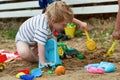 Little boy plays in the sand with plastic toys Royalty Free Stock Photo