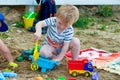 Little boy plays in the sand with plastic toys Royalty Free Stock Photo