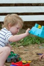 Little boy plays in the sand with plastic toys Royalty Free Stock Photo