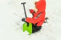 Little boy plays with a snow shovel in a pile of snow Royalty Free Stock Photo