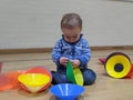 A little boy plays with a stack of sports cones