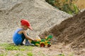 Little boy plays with a toy tractor