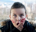 Little boy posing with painted hearts on the face