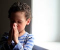 Little boy praying to God with hands held together stock photo Royalty Free Stock Photo