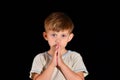 A little boy prays to God with his hands tucked open with his eyes open. Royalty Free Stock Photo