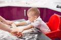 Little boy preparing dough. Boy kneads dough in the kitchen Royalty Free Stock Photo