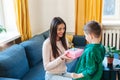 Little boy presenting gift to happy mother on Mothers Day Royalty Free Stock Photo