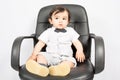 Little Boy pretending as businessman sitting on desk in office