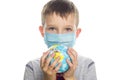 Little boy in protective sterile medical mask is holding a world globe. Save planet. The concept of preventing the spread of the