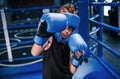 Little boy in protective wear and with nose bleed training in the boxing ring