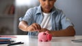 Little boy putting pocket money in piggy bank, raising funds for desired toy Royalty Free Stock Photo