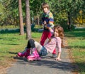 A little boy raises his sister who fell on roller skates. Royalty Free Stock Photo