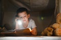 Little boy reading book in play tent at night Royalty Free Stock Photo