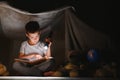 little boy reading book in play tent at night Royalty Free Stock Photo