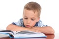 Little boy sitting at the table reading a book Royalty Free Stock Photo