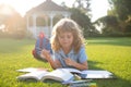 Little boy reading a book in summer sunset light. Preparation for school and international literacy day. Back to school